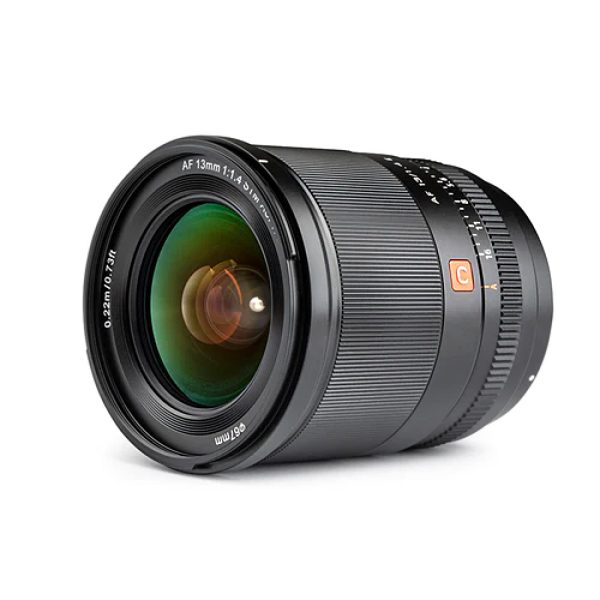 Sony E:lle tarkoitetun Viltrox AF 13mm f/1.4 -objektiivin lähikuvassa näkyy musta objektiivi, jossa on kuvioidut tarkennus- ja zoomausrenkaat, vihreät heijastukset lasissa ja valkoiset merkinnät 13 mm:n polttoväli- ja f/1.4-16-aukkoasetuksille.