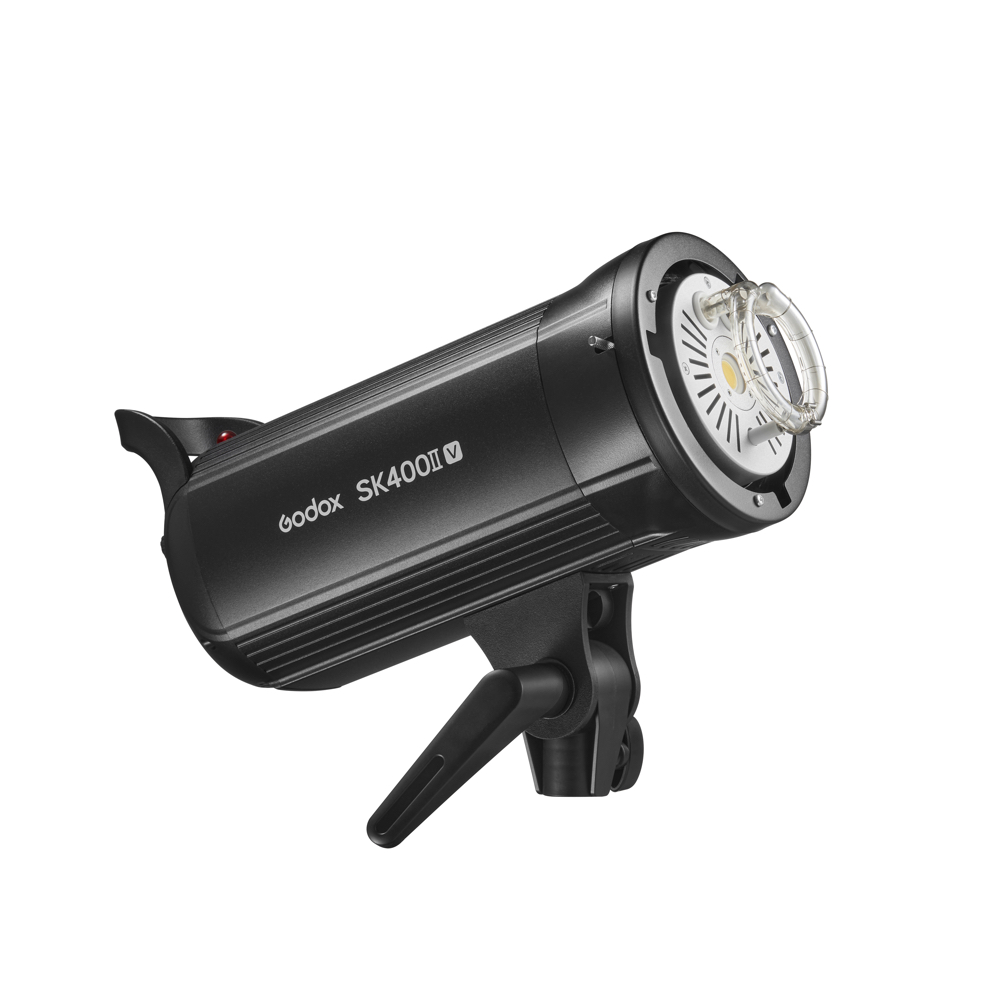 Musta Godox SK400II-V -studiostroboskooppivalaisin, jossa on kahva ja kiinnitysteline, on esillä kulmassa, ja sen lamppu ja etuosa näkyvät valkoista taustaa vasten.