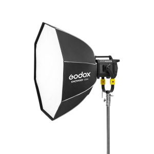 Ammattikäyttöön tarkoitettu Godox GO4 Octa Softbox 120cm KNOWLED MG1200Bi -valaisimelle on asennettu jalustalle ja suunnattu vasemmalle valkoista taustaa vasten.