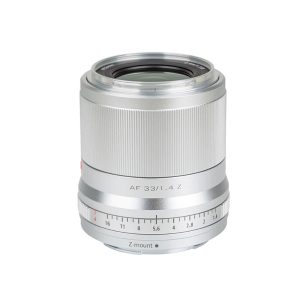 Viltrox AF 33mm f/1.4 -objektiivi Nikon Z:lle, kuvassa hopeanvärinen, jossa on uurrettu tarkennusrengas ja aukkoasteikko (f/1.4-f/16), on kuvattu valkoista taustaa vasten.