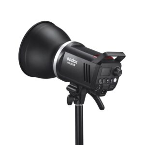1682431399_792 Musta Godox MS300V -studiostroboskooppivalaisin on asennettu jalustalle, ja sen ohjauspaneeli, kahva ja virtajohdon sisääntulo ovat esillä. Valaisin on suunnattu vasemmalle, mikä korostaa sen tyylikästä ja ammattimaista muotoilua.