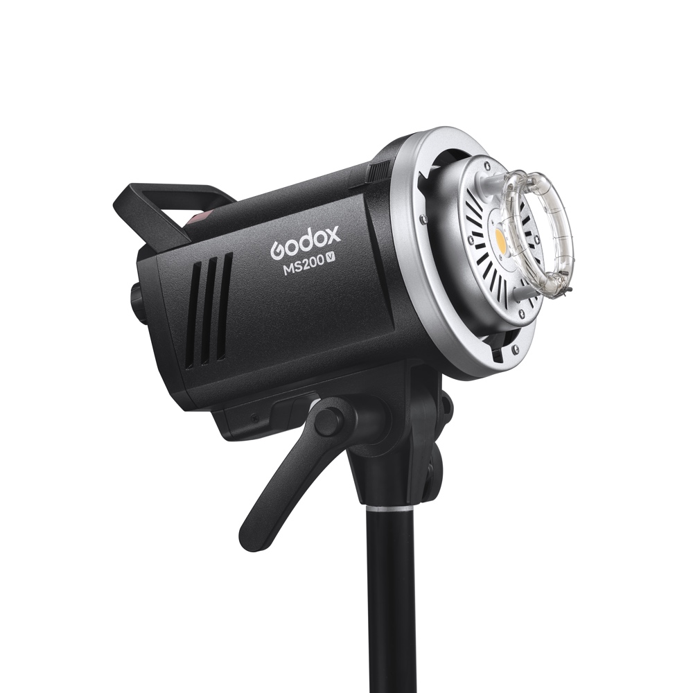 Musta Godox MS200V -studiostroboskooppivalaisin on asennettu valotelineeseen, hieman ylöspäin taivutettuna, ja siinä on näkyvät säätimet ja pyöreä salamaputki edessä.
