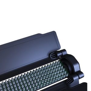 Lähikuva Viltrox H18 Bi LED RGB -valotikusta, jossa on musta elektroninen komponentti, jossa on useita pieniä metallisia koskettimia, jotka on sijoitettu riveihin ja osittain suojakotelon sisään, valkoista taustaa vasten.