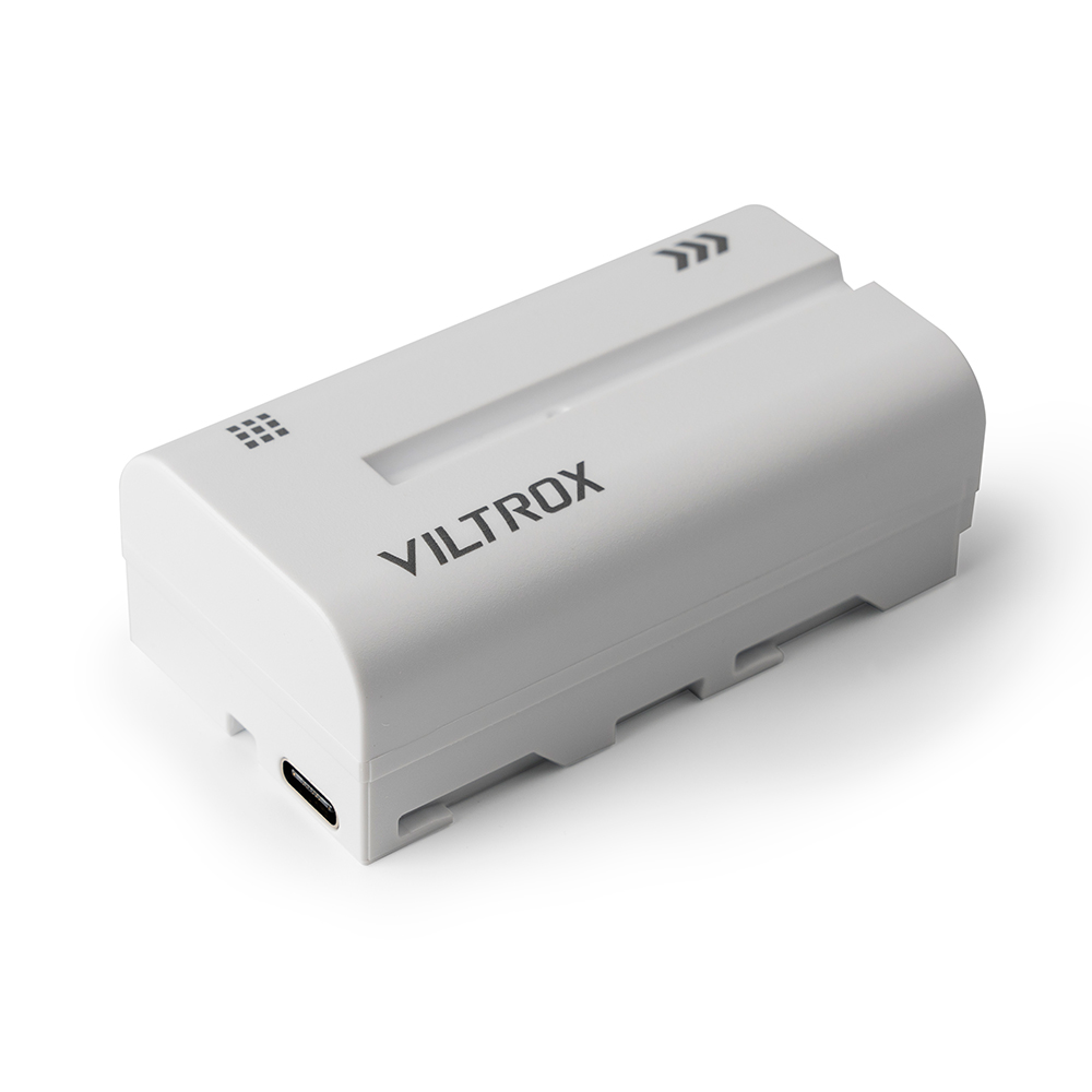 Valkoisessa Viltrox NP-F550 -kameran akussa on USB-C-portti, musta painettu logo ja kaksi nuolisymbolia valkoisella pohjalla.
