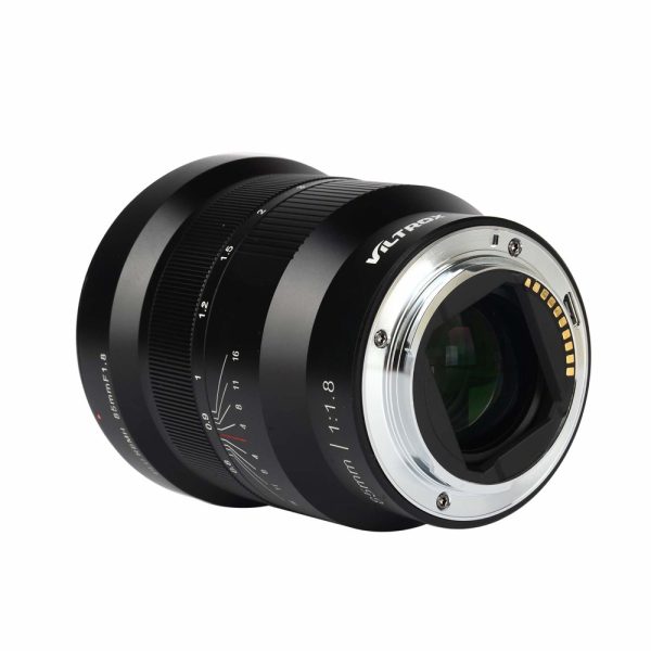 Viltrox MF 85mm f/1.8 PFU RBMH -objektiivi Sonylle URTH KIT:stä (UV Plus+), mustana, elektronisilla koskettimilla ja manuaalisen tarkennuksen merkinnöillä varustettuna, kulma käännettynä niin, että sen lasielementit ja metallinen kiinnitys tulevat esiin.