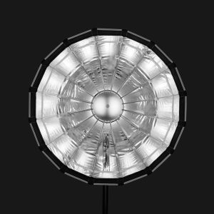 Godox Multifunctional Softbox S65T, suuri pyöreä studiovalaisin, jossa on hopeanvärinen heijastava sisäpinta ja säteittäiset tukikylkiluut, on kuvattu pää edellä mustaa taustaa vasten.
