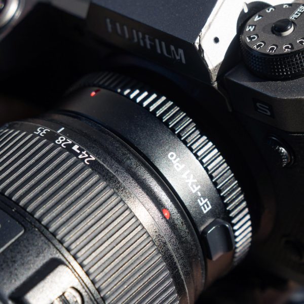 Close-up of a Fujifilm camera with the Viltrox EF-FX1 PRO Autofocus Adapter attached, highlighting the detailed markings and textures on both the adapter and the camera body.