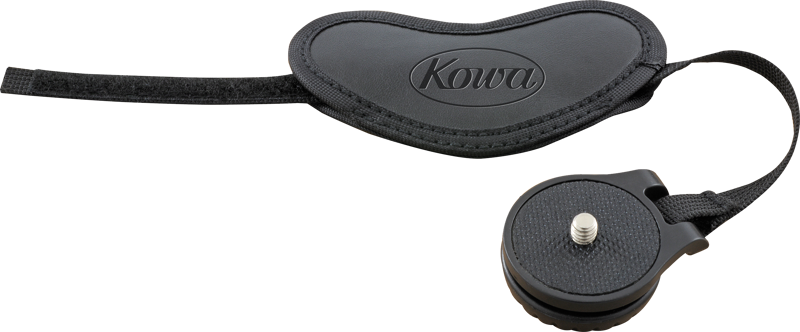 KOWA Hand Strap for Spottingscope on kuvattu vaalealla pohjalla, ja siinä on Kowa-tuotemerkki kohokuvioitu mustaan hihnaan, jossa on säädettävä kiinnitys. Sen vieressä on pyöreä musta ruuvikiinnitteinen lisävaruste.