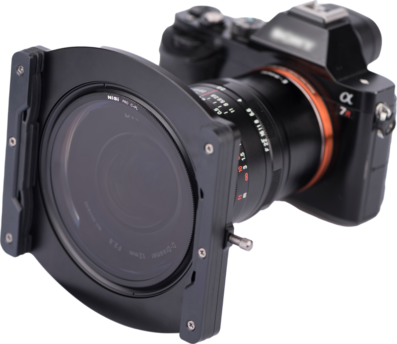 The Nisi Filter Holder Kit for Laowa 12mm f/2.8 is attached to the lens of a digital camera, and is pictured mounted on the front of the lens against a white background.