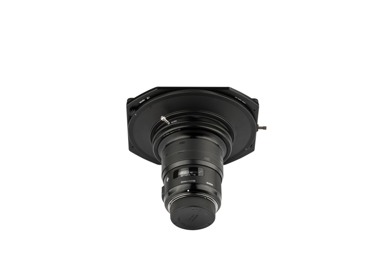 The NiSi Filter S5 Adapter for Sigma 20mm f/1.4 (adapter only) is pictured mounted on a flat, black, hexagonal surface against a white background, facing downwards and with the labels and adjustment rings visible.