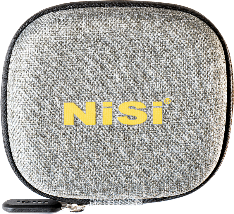 Pienikokoinen, neliönmuotoinen, harmaa, kuvioitu NiSi-suodatinkotelo P1-suodattimille, jossa on vetoketju ja rohkea keltainen "NiSi"-kirjain etupuolella.
