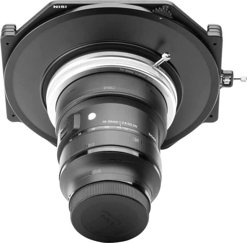 NiSi Filter Holder S6 Kit True Color for Sigma 14-24mm f/2.8 DG DN (E-Mount) -levysuodin pidike näkyy asennettuna laajakulmaobjektiiviin, korostaen sen suurta lasielementtiä ja kiinnitysjärjestelmää vaaleanharmaata taustaa vasten.
