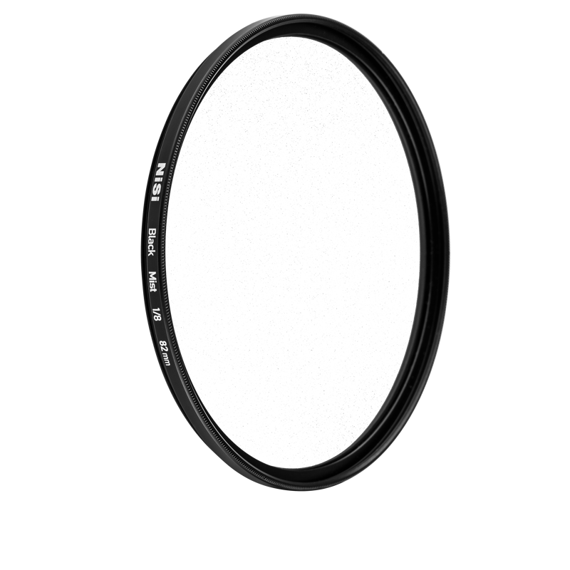 Round NiSi filter Black Mist 1/2 52mm diffusion filter with black metal frame stands upright against a white background. The filter size, 52mm, is marked on the edge.