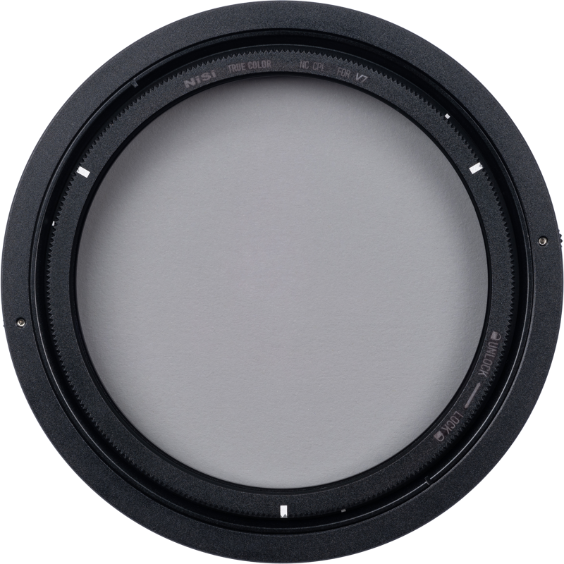 NiSi Filter True Color CPL for V7 Holder, jossa on musta ulkokehä ja kirkas keskikehä, jossa on merkintöjä ja tekstiä sisäkehässä, näkyy ylhäältä päin tavallista vaaleaa taustaa vasten.