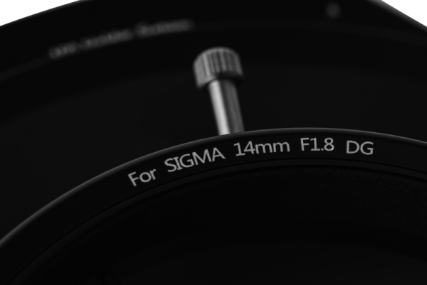 Close-up of the NiSi Filter S5 Adapter for Sigma 14mm f/1.8 (adapter only) lens, showing the metal control knob above the product label against a dark background.
