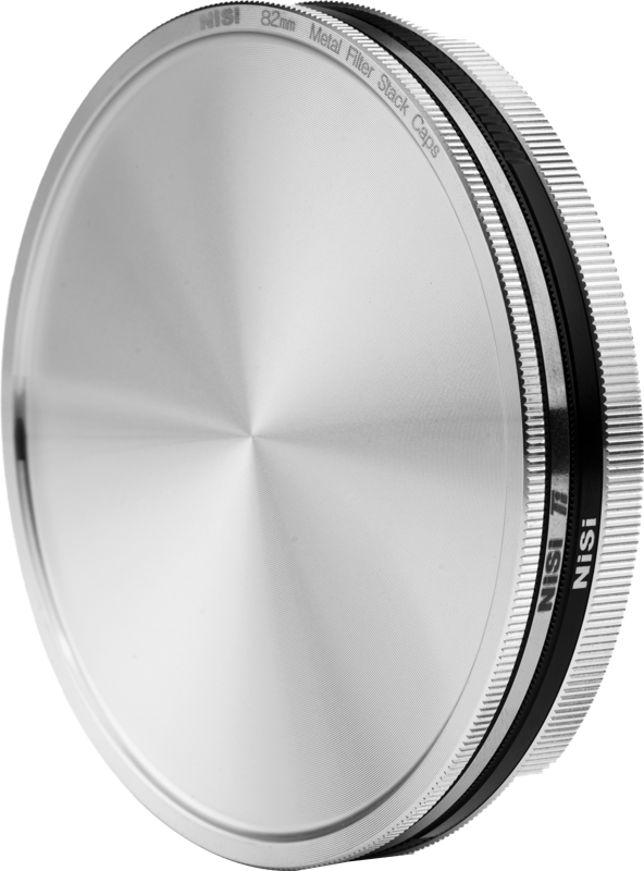 NiSi Filter Stack Caps 82mm -suodatinkorkkien lähikuvassa näkyy sen metallinen, pyöreä muotoilu, jossa on kuvioitu pinta ja kaiverrettu reunusteksti vaaleaa taustaa vasten.