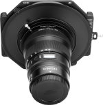 Etunäkymä NiSi-suodattimen pidikkeestä S6 Kit True Color for Nikkor Z 14-24mm f/2.8 S -levysuodin pidike kiinnitettynä kameran objektiiviin, kuvattu vaaleaa taustaa vasten.