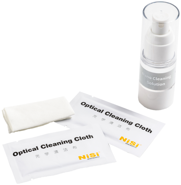 800q-02_117363 NiSi Cleaning Kit Nano Optical, jossa on pullo Nano Cleaning Solution -puhdistusliuosta, kaksi pakattua NiSi-optista puhdistusliinaa ja taittamaton valkoinen liina, on esillä valkoisella pinnalla.
