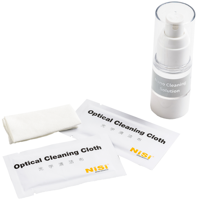 800q-02_117363 NiSi Cleaning Kit Nano Optical, jossa on pullo Nano Cleaning Solution -puhdistusliuosta, kaksi pakattua NiSi-optista puhdistusliinaa ja taittamaton valkoinen liina, on esillä valkoisella pinnalla.