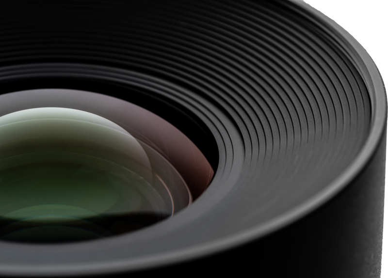 Lähikuva NiSi Cine Lens Athena Prime 18mm T2.2 PL-Mount -objektiivista, jossa näkyvät yksityiskohtaiset urat ja lasin heijastukset, jotka paljastavat objektiivin hienon rakenteen ja pyöreän muotoilun.