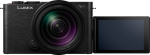 The Panasonic Lumix S9 Jet Black with 28-200mm f/4-7.1 Macro lens is seen from the front. Its LCD screen is turned to the right, off, and shows a blank, dark surface.