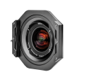 Lähikuva NiSi-suodattimen pidikkeestä (100mm) Laowa 10-18mm f/4.5-5.6 -levysuodin pidikkeestä kiinnitettynä objektiiviin, eteenpäin päin, tavallista valkoista taustaa vasten, jossa on näkyviä lasielementtejä ja värikkäitä heijastuksia.