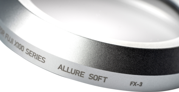 Lähikuva NiSi-suodattimesta Allure Soft for Fuji X100 (Silver) diffuusiosuodin, jossa näkyy kaiverrettu teksti "ALLURE SOFT, FX-3, FUJI X00 SERIES" sen metallisella renkaalla, joka on todennäköisesti osa kameran linssisuodinta.