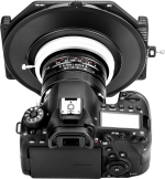 Musta Canon DSLR-kamera, jossa on NiSi-suodattimen pidike S6 Kit Laowa 15mm f/4.5 W-Dreamer -levysuodin pidike asennettuna objektiiviin, ylhäältä katsottuna, jossa näkyy kameran painikkeet, näyttö ja säätimet.