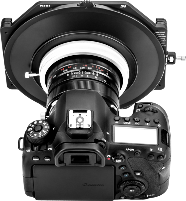 Musta Canon DSLR-kamera, jossa on NiSi-suodattimen pidike S6 Kit Laowa 15mm f/4.5 W-Dreamer -levysuodin pidike asennettuna objektiiviin, ylhäältä katsottuna, jossa näkyy kameran painikkeet, näyttö ja säätimet.