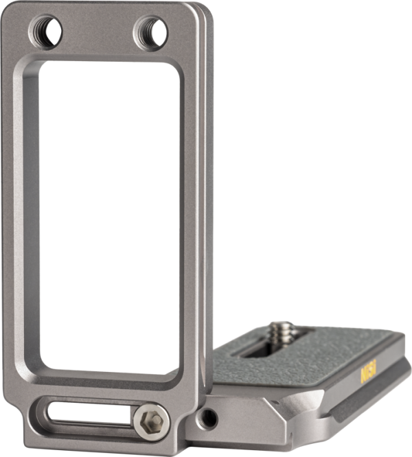 NiSi Universal Adjustable L-Plate NLP-S, hopeinen metallikannatin, jossa on kuvioidut tartunta-alueet ja useita ruuvikiinnikkeitä kameran kiinnittämistä varten, seisoo pystyssä kevyellä pinnalla.