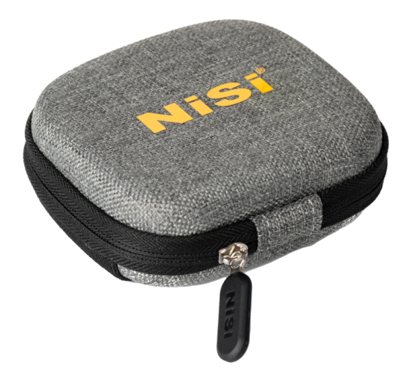Pieni, neliönmuotoinen harmaa kangaskotelo, jossa on musta vetoketju ja vetokieleke ja jonka yläosassa on NiSi-logo keltaisella. Suunniteltu NiSi Filter IP-A Filmmaker Kit for iPhone -kuvaussarjalle.
