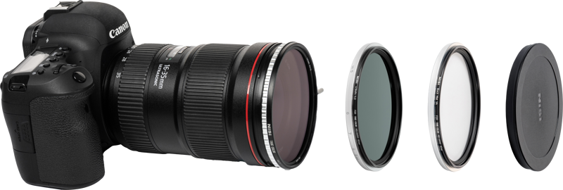 Canon DSLR -kameran ja siihen kiinnitetyn objektiivin vieressä on NiSi Filter Swift System Add On Kit 67mm, jossa on kolme ympyräsuodatinta ja linssinsuojus rivissä oikealla.