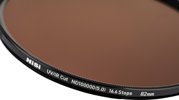 Lähikuva NiSi Pro Nano IR ND100000 77mm harmaasuodin linssisuodattimesta, jossa korostuu teksti ja yksityiskohdat sen mustassa metallireunassa vaaleaa taustaa vasten.