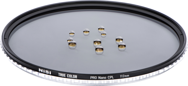 Lähikuva NiSi Circular True Color Pro Nano CPL 112mm -suodattimesta Nikon Z 14-24mm f/2.8S -pyöröpolarisaatiosuodin vesipisaroilla korostaa sen vettähylkivää pinnoitetta.