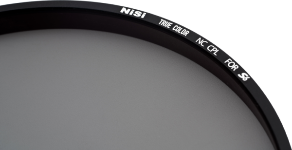 Lähikuva NiSi Filter Circular for S6 Circular Polariser True Colour CPL -levysuodin valkoista taustaa vasten, jossa osa mustasta reunasta valkoisella tekstillä.
