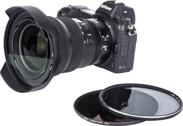 Nikon Z 14-24mm f/2.8 -kamera, jossa on laajakulmaobjektiivi ja siihen liitetty NiSi NC UV 112mm -suodatin, on kahden pyöreän linssisuodattimen vieressä valkoisella taustalla.