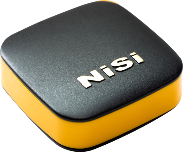 Pienikokoinen, neliönmuotoinen musta-keltainen kotelo, jossa on pyöristetyt reunat ja jonka yläosassa lukee "NiSi" korotetuin valkoisin kirjaimin, on suunniteltu NiSi Remote Control Bluetooth -kaukosäätimelle.