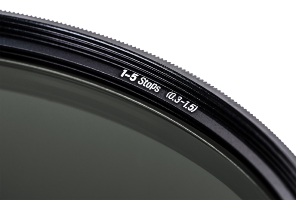 Lähikuva NiSi TRUE COLOR ND-VARIO 1-5 Stop 105mm -säädettävästä harmaasuodinista, jossa näkyy valkoinen "1-5 Stops (0.3-1.5)" teksti reunassa, osa lasista ja harjattu metallireuna tavallista taustaa vasten.