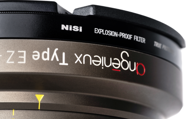 Close-up of a camera lens fitted with the NiSi Cine Filter Explosion Proof / True Protector AG-11175 for Angenieux EZ-1 & 2, showing "angenieux Type EZ" and filter markings on sharp metal and black surfaces.