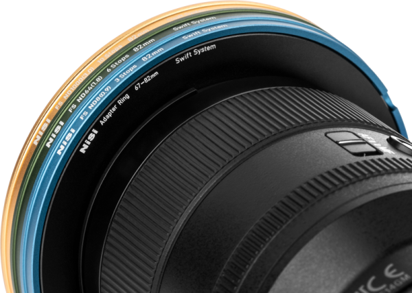Close-up of the NiSi Filter Swift System FS ND Kit (8+64+1000) 40.5-49mm grey filter lens and its multicoloured filter adapter ring, with filter sizes and details marked.