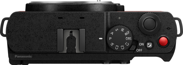 Panasonic Lumix S9 -järjestelmäkameran, Crimson Red, ylhäältä katsottuna, jossa näkyvät säätöpyörät, painikkeet, kuumakenkäkiinnitys ja virtakytkin kuvioidulla pinnalla. Kamera on asetettu vaakasuoraan.