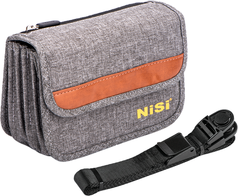 NiSi Filter Pouch Pro 100mm Caddy on harmaasta kankaasta valmistettu kameran tarvikepussi, jossa on ruskea aksentti ja keltainen NiSi-logo, kuvassa mustan säädettävän hihnan ja muoviklipsin vieressä.