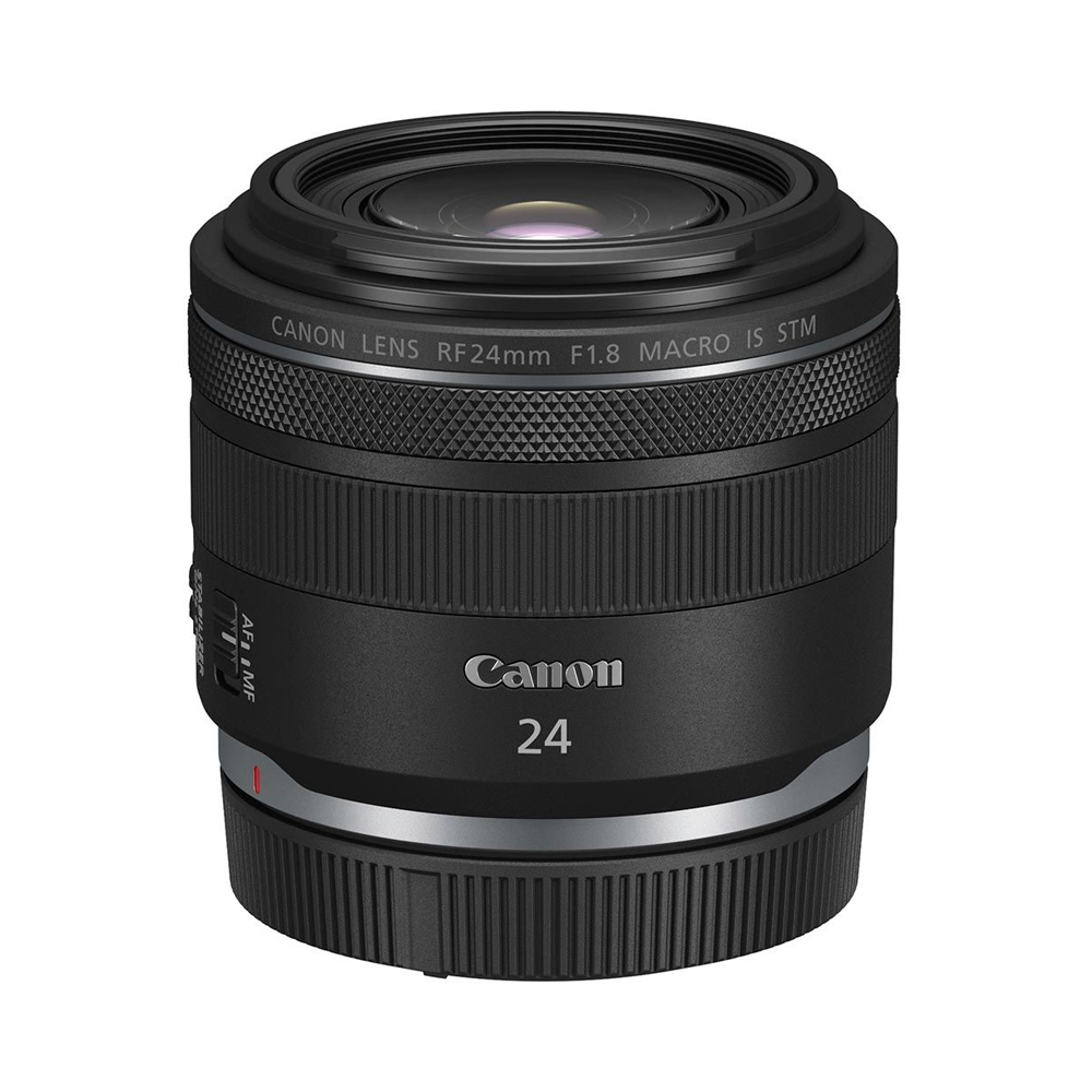 Canon RF 24mm f/1.8 Macro IS STM -objektiivi näkyy valkoisella taustalla, ja sen musta muotoilu, Canon-brändi ja objektiivin yksityiskohtaiset tiedot korostuvat.