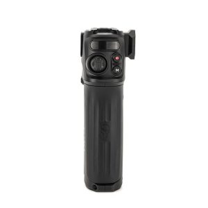 TiltaNH_002 TILTA Nucleus Nano II Handle on musta elektroninen kädessä pidettävä laite, jossa on kuvioitu kahva, ohjauspainikkeet ja pieni joystick etupuolella, kuvassa pystyasennossa valkoista taustaa vasten.