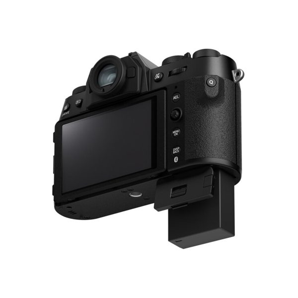 Fujifilm X-T50 system camera, black, shown from the back with LCD screen and control buttons visible, battery compartment open and battery partially inserted under the body.