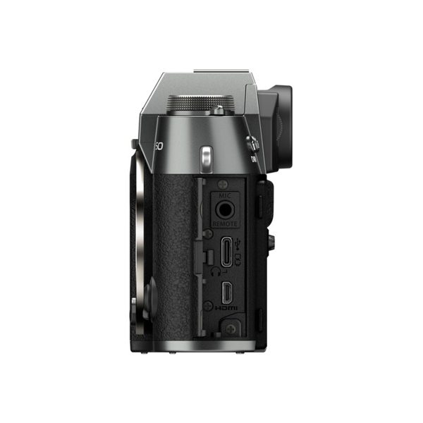 Side view of the Fujifilm X-T50 system camera, grey shows the microphone, remote control, mini HDMI and micro USB ports on its textured grip, with the viewfinder and steering wheel visible on top.