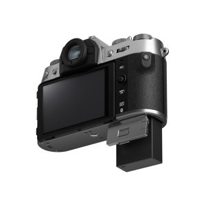 Fujifilm X-T50 system camera, silver rear view, with retractable LCD screen, multiple control buttons, semi-retractable battery in the bottom box and a stylish black and silver finish.