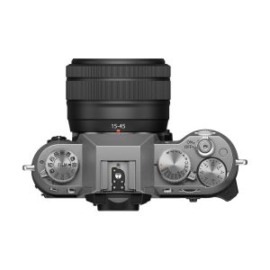 Fujifilm X-T50 + XC 15-45mm f/3.5-5.6, hopea -digitaalikamera mustalla 15-45mm objektiivilla. Näkyvissä ovat moodivalitsin, suljinnopeuden säädin, on/off-kytkin, painikkeet ja keskellä oleva hot shoe.