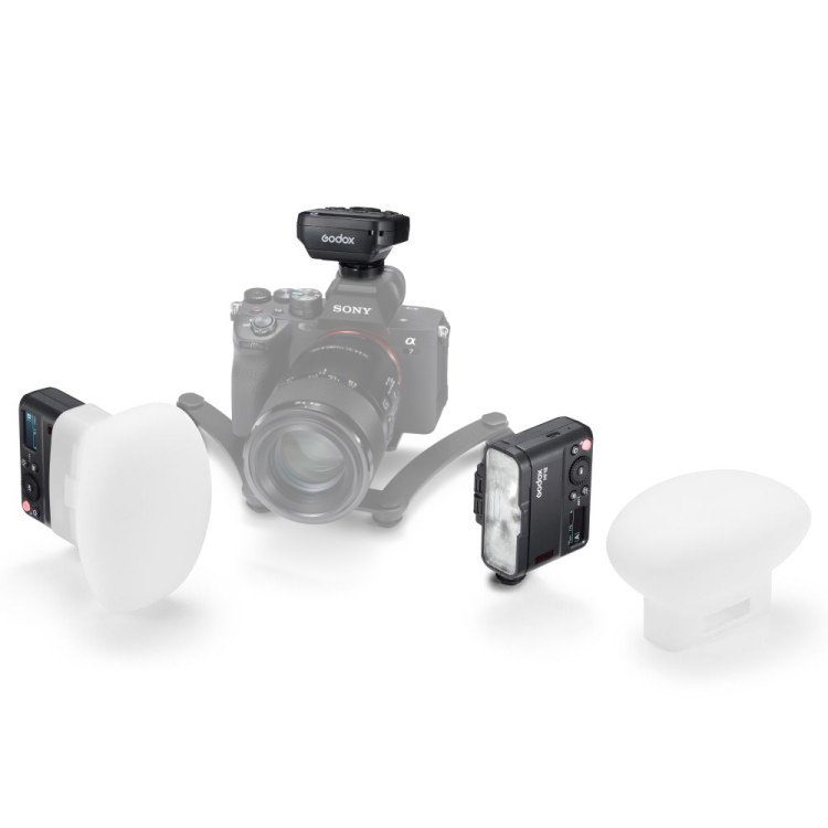 Sony-kamera, jonka päälle on asennettu Godox MF12-DK1 Dental Flash Kit -makrosalama -laukaisin, on ympäröity kahdella salamalaitteella ja kahdella valkoisella diffuusorilla, jotka on sijoitettu valkoiselle taustalle.