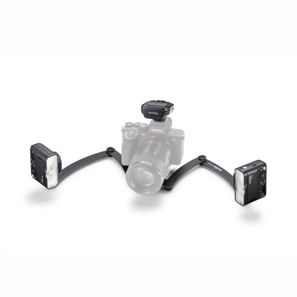 Godox MF12-DK2 Dental Flash Kit -makrosalama on esitetty pöydällä, kamera on kaksivartisella kiinnikkeellä, ja kummassakin varressa on MF12-salama ja sen päälle asennettu langaton laukaisin.